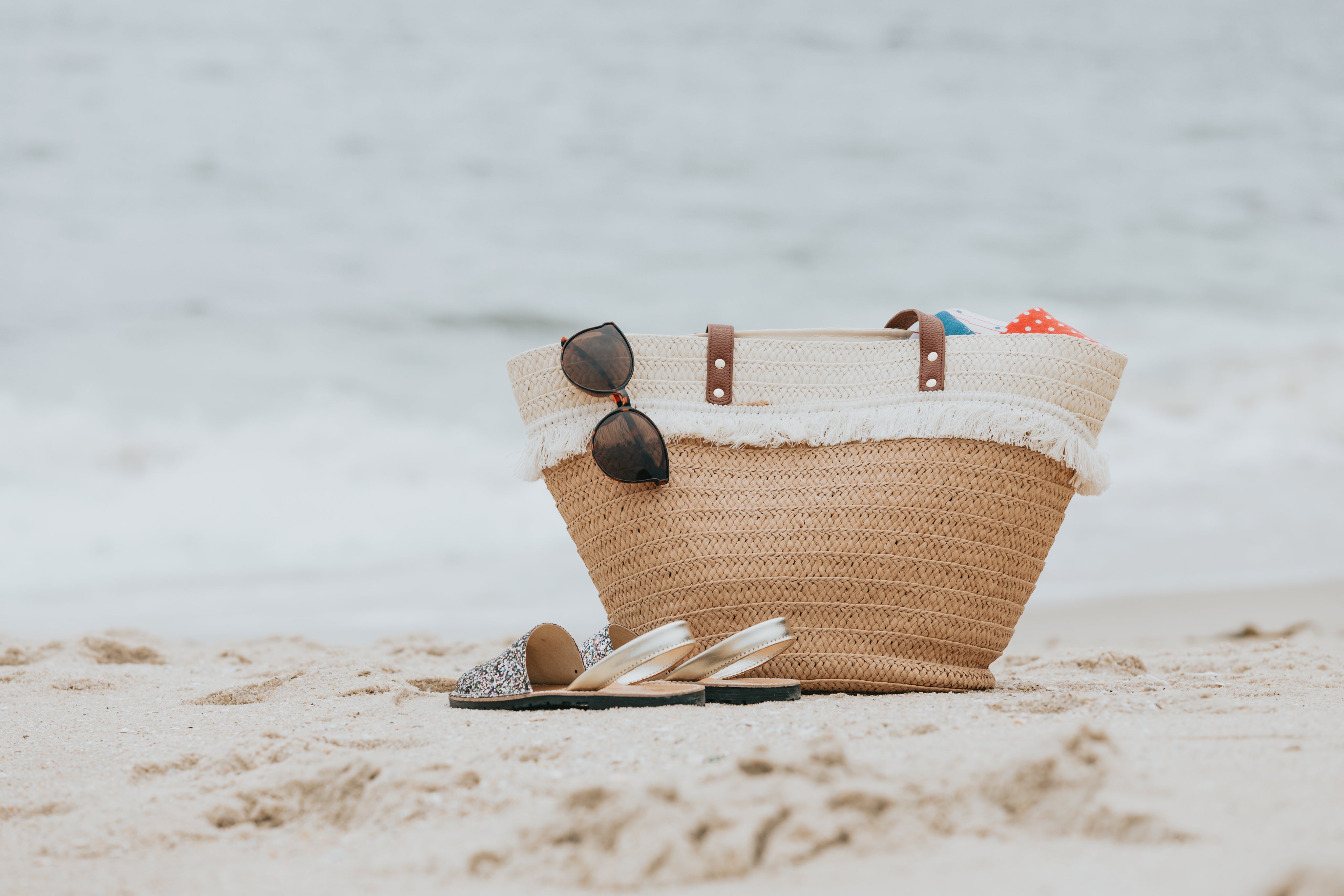 sandals-and-a-beach-bag-on-a-white-sandy-beach.jpg
